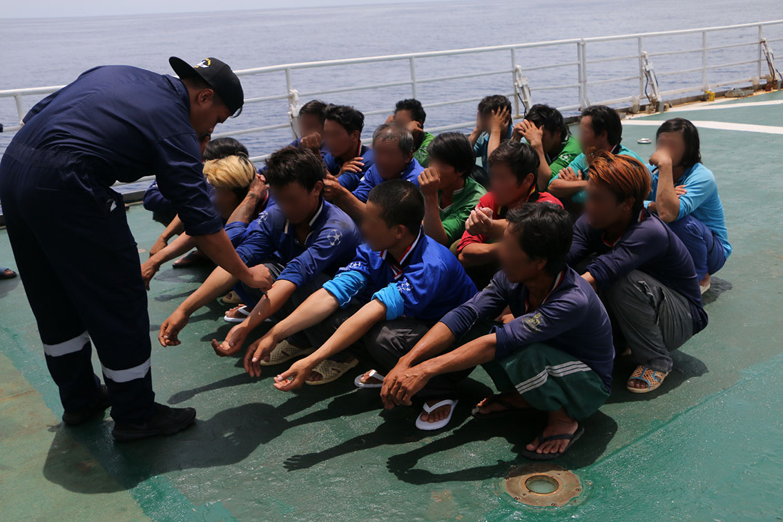海事执法局将部分被逮捕的非法渔民，押上执法船只。