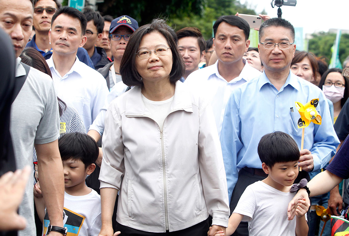 台湾总统蔡英文（中）手牵两个小朋友，在台北上街游行。（美联社）