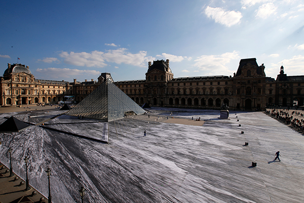 法国艺术家将罗浮宫金字塔周围变成巨大陨石坑。（法新社）