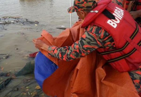 消拯员在河面打捞疑是投河自尽的男子遗体。