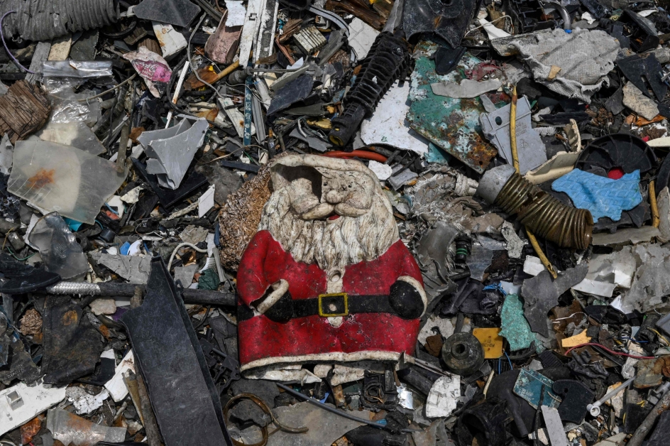 一个圣诞老人躺在一堆废弃垃圾中。