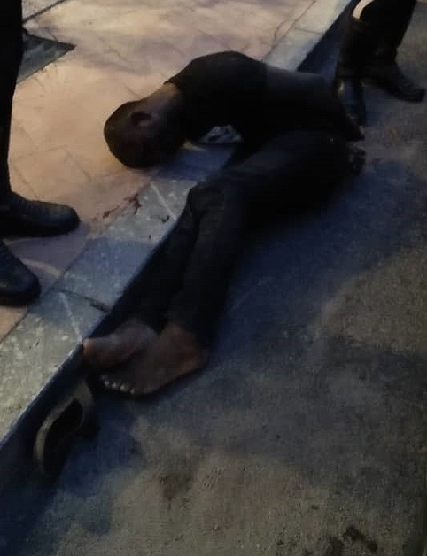嫌犯被群众制伏后，躺在路旁。