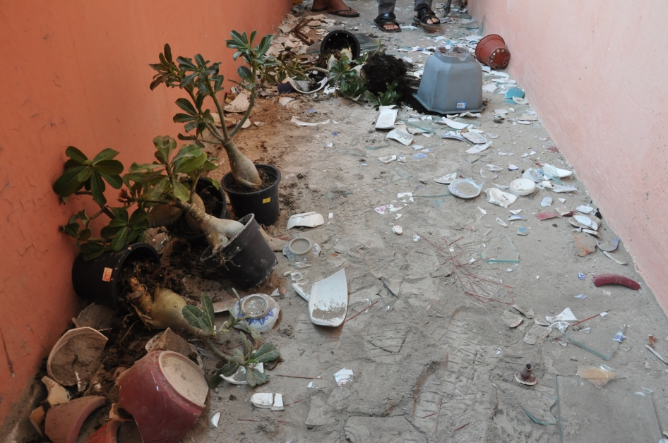 疯妇住家走廊满地是碎裂花盆和玻璃碎。