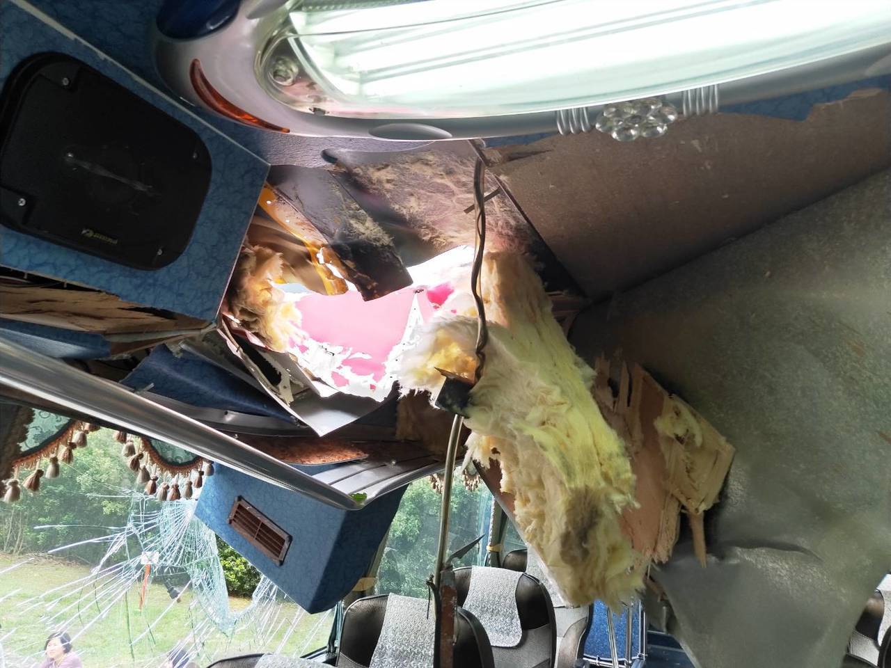 旅游巴士被落石砸破车顶和挡风玻璃。
