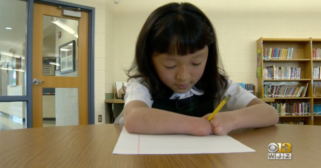 天生没有手掌的10岁华裔领养女孩莎拉获得全国学童写字比赛冠军。