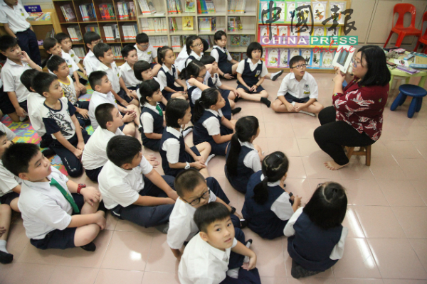 教师阅读绘本为培德小学学生讲故事。