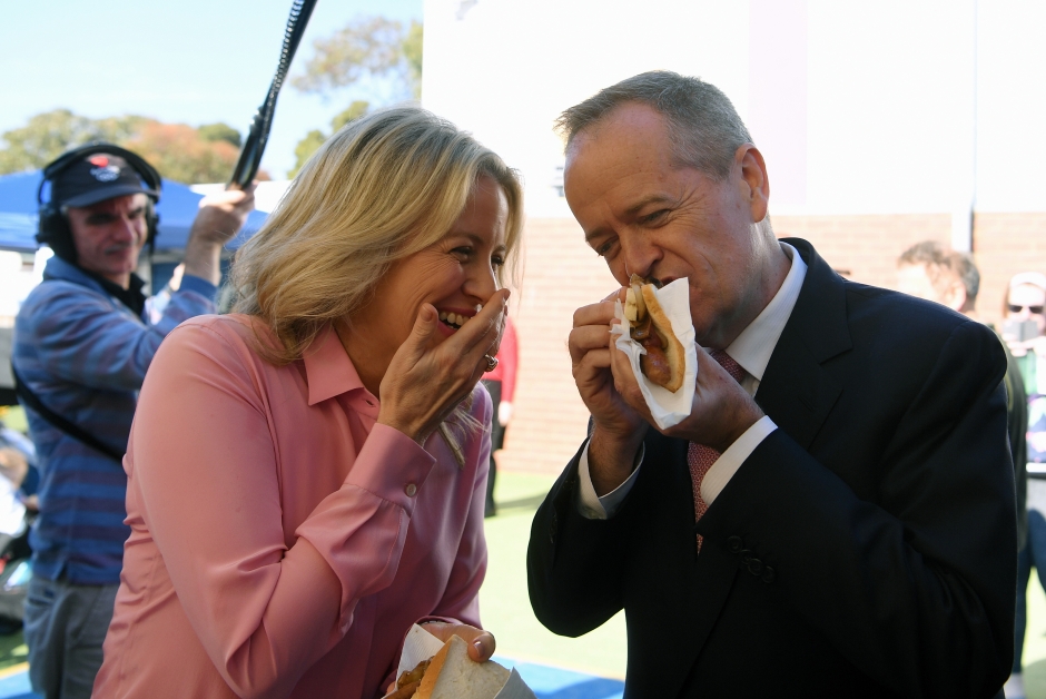 工党领袖肖特（右）和妻子克劳伊在投票当天大吃“民主香肠”。（欧新社）