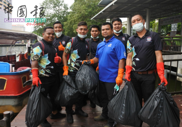 阿兹兰（右2）与员工们合力清理了数十袋的垃圾。