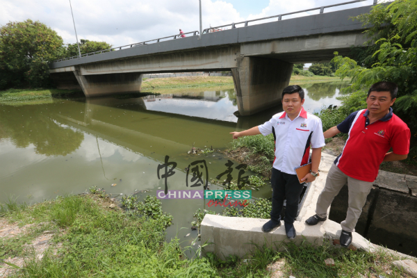 张文杰（左起）与洪清顺察看布满鱼尸的玛琳河。