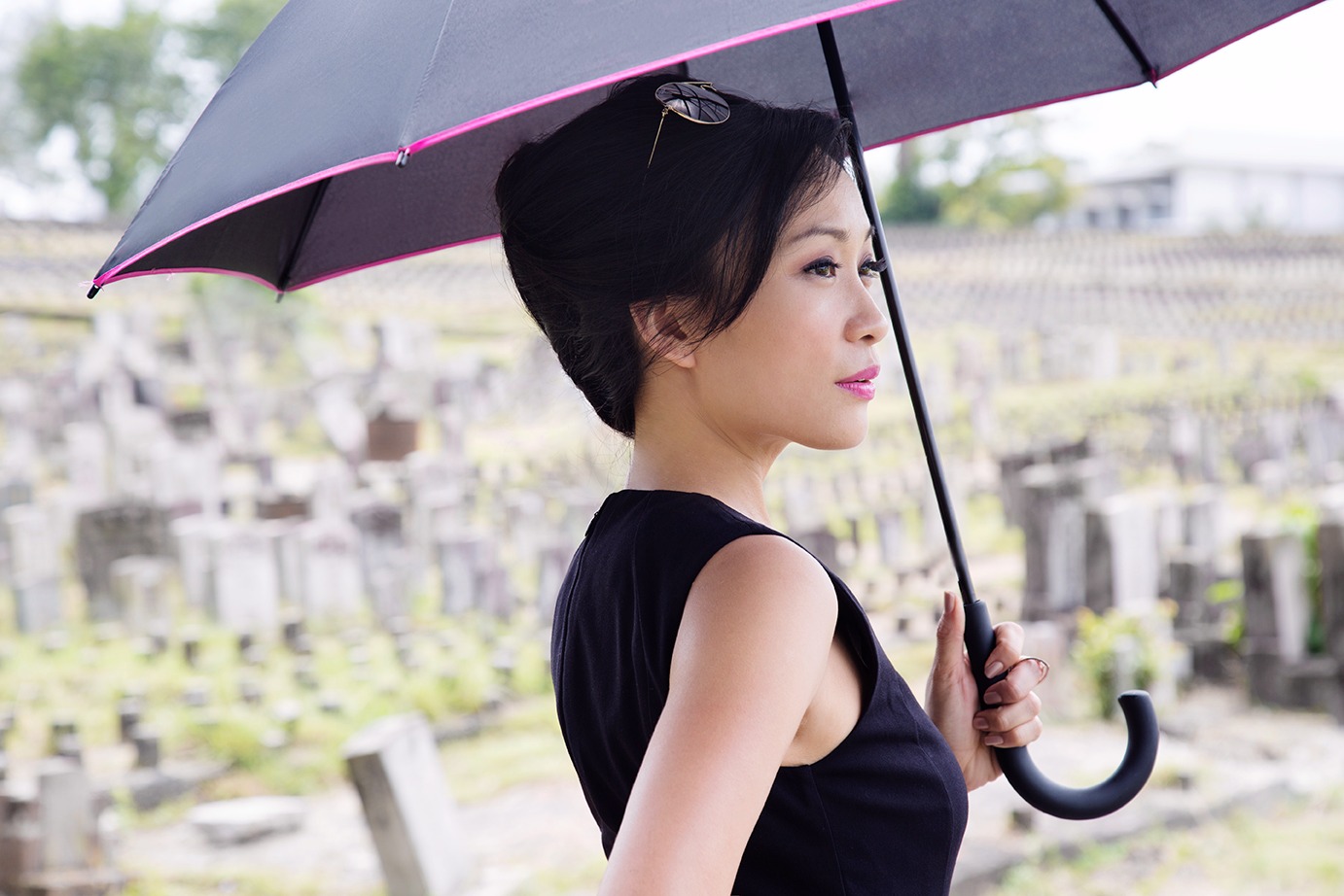 洪钰绣出版中文自传《爱的告别》，烈阳下在坟场优雅地撑伞。