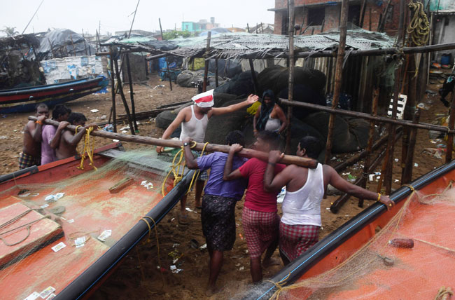 印度东部沿岸地区的渔夫周四合力将船只拉往更高处安置，以免遭遇极强气旋风暴法尼的侵袭而有所损失。（法新社）