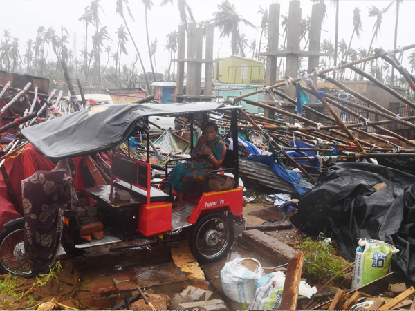 印度度假圣地普里遭受“法尼”肆虐蹂躏，当地建筑物被狂风暴雨吹倒坍塌，椰子树岌岌可危，一名女居民坐在一辆电动人力车上无助无奈，神情忧伤。（法新社）