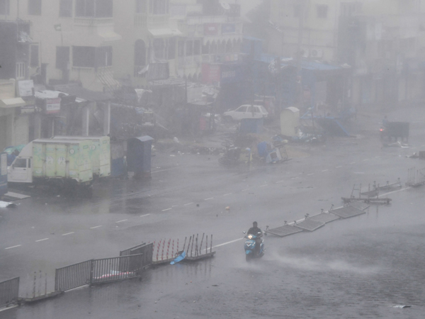 印度一名居民沿着公路骑摩哆车逃命。猛烈的“法尼”袭击印度东部，整个普里地区陷入朦胧的大风大雨中，曝露在外的一切无一幸免，摊位被吹翻，栏杆被吹倒。（发新社）