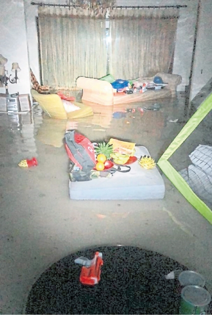 水涌入低洼地势民宅，客厅的家具都泡在水中。