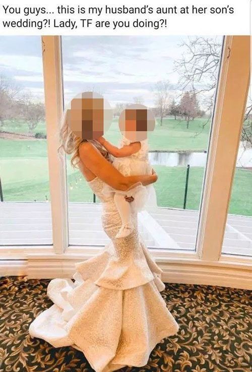 儿子阿妈身穿类似婚纱款式的白色礼服，抱花童拍照。