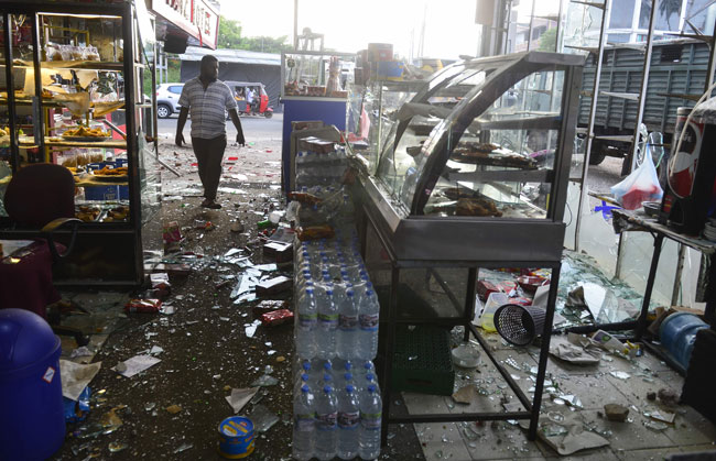 北部米努万戈德市一间店铺遭到暴民破坏，玻璃碎满地。（法新社）