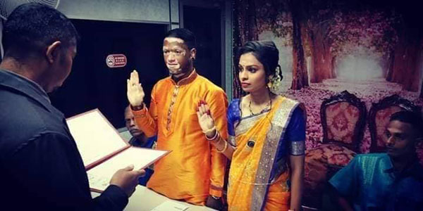 2名印裔男女在见证人的见证下，签名结婚。