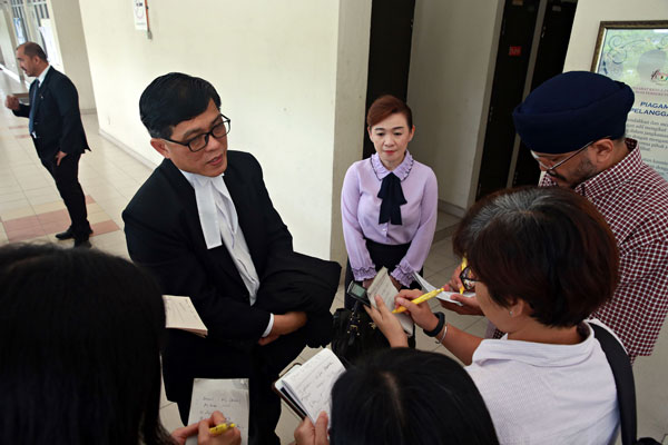 黄觥发（左起）及蔡礼嫔向记者讲解法官的判决。