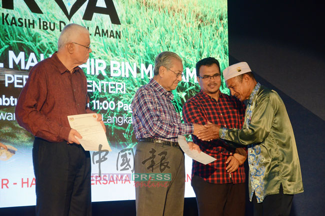 马哈迪（左2）移交援助金给因旱灾祸害而蒙受损失的农民。