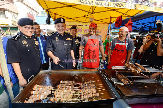 阿都哈密（前排左2）在吉隆坡总警长拿督斯里马玆兰陪同下到斋戒月市集巡视，并尝试亲自烧烤。