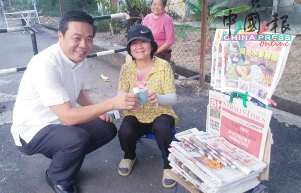 在308妇女节，郑国球（左）送花给一名小贩。