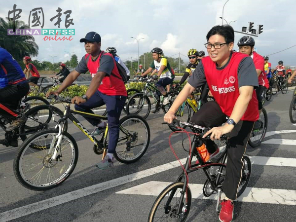 杨勇平（右）参与在汉哲拔体育馆举行的脚车行活动。