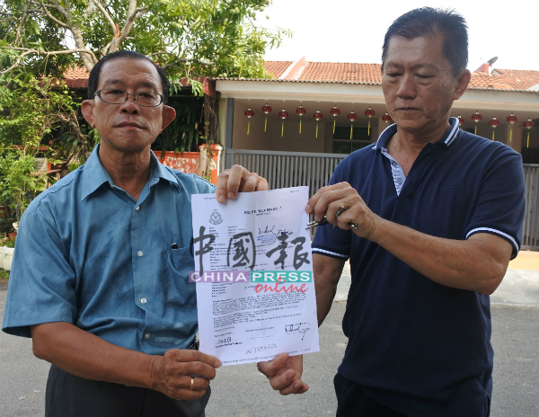 郑瑞源（右起）向林祥和展示报案纸。