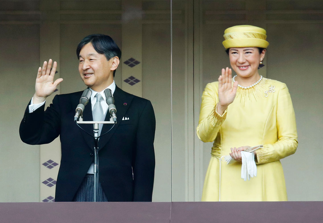 新日皇德仁（左）与皇后雅子在长和殿阳台上带笑向民众挥手。（美联社）