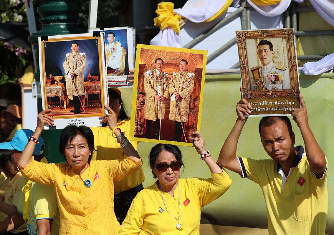 穿着黄衣的民众在曼谷大王宫高举泰王的肖像。