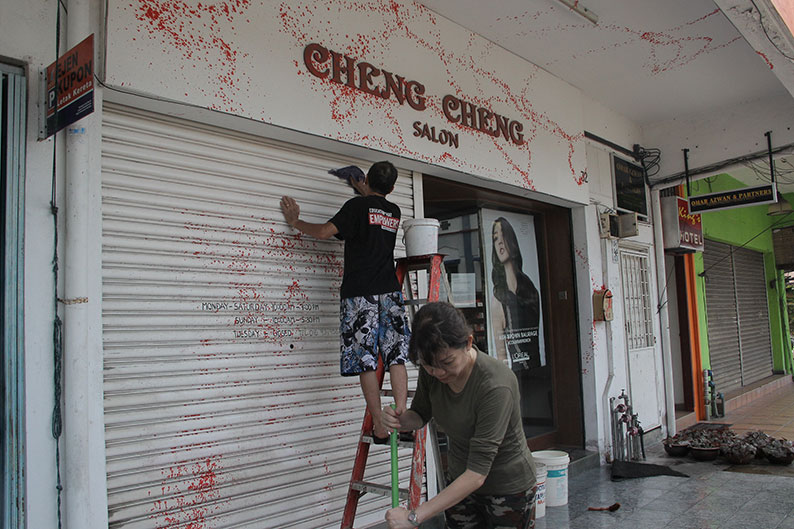业者夫妇大清早即忙于清洗店面斑斑红漆。