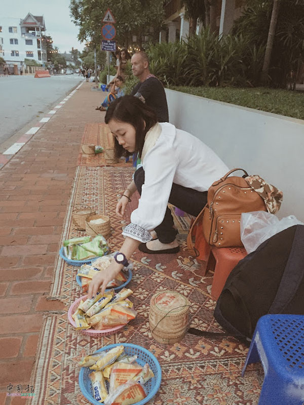 走在清晨静谧街上，到处都是在兜售蒸笼糯米饭和小吃的小贩，以供布施之用。