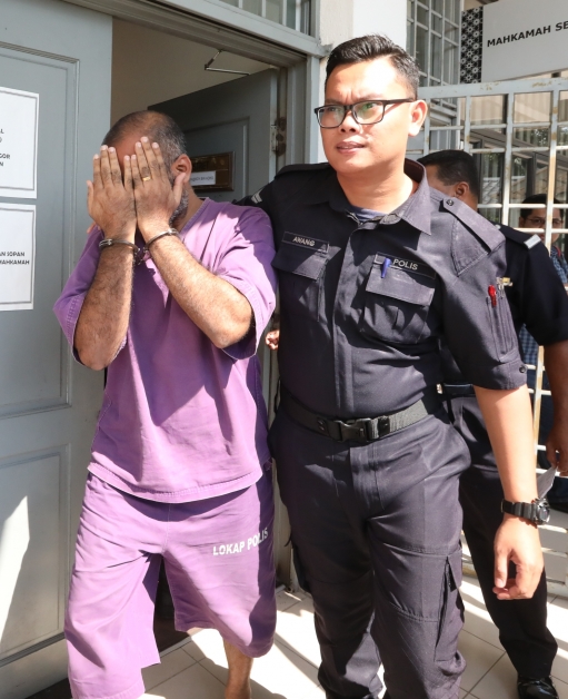 拉苏古兰（左）在庭警押送下离开推事庭。