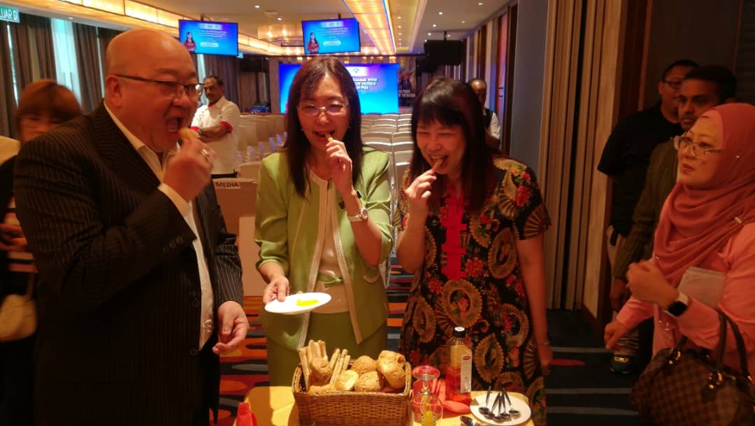 邱武林（左起）、郭素沁和林慧英，拿面包沾棕油吃。