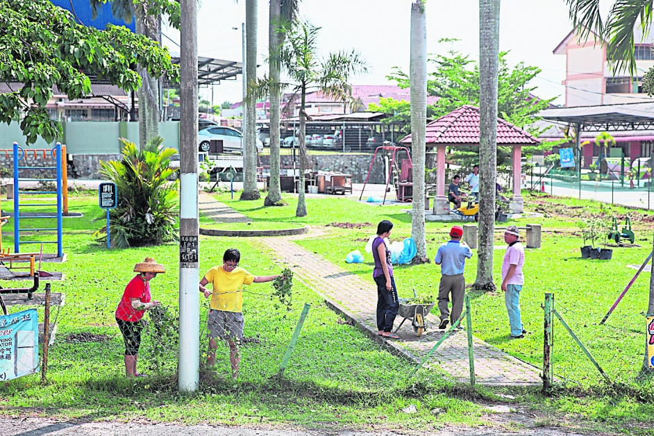 学生与村委会合作为儿童游乐场进行大扫除。