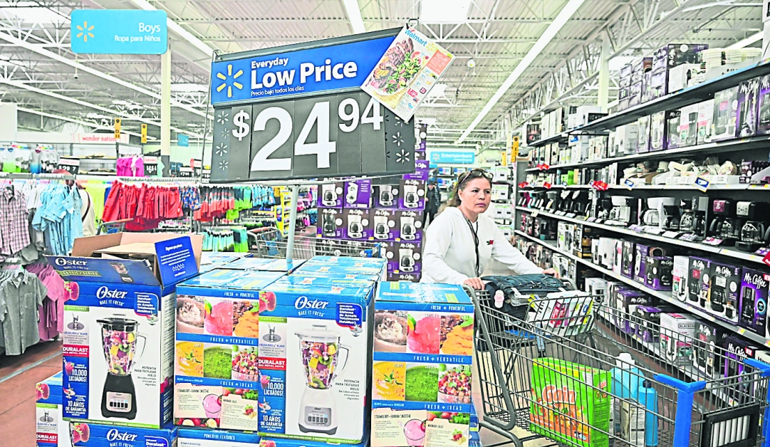 顾客在加州的沃尔玛连锁超市内购物。受到贸易战影响，约有26%进口货品来自中国的沃尔玛最近说，旗下出售货品将加价。（法新社）