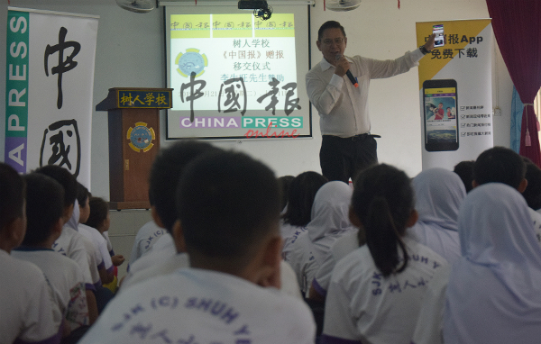 林钦为在师生面前介绍《中国报》APP，让他们免费阅读网络新闻。