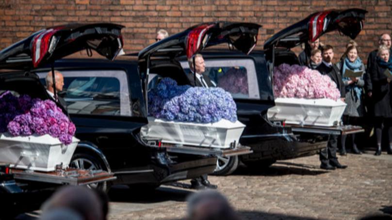 3副白棺上摆着粉红色和紫色的花。