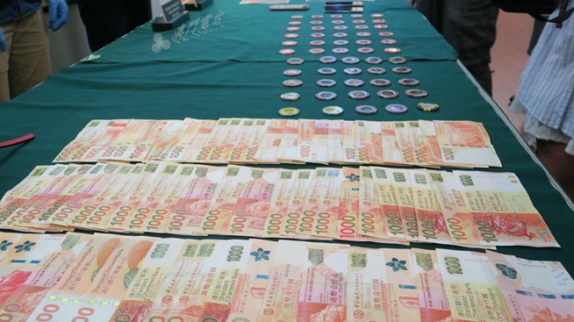 澳门警方展示起获的港元现金及筹码。