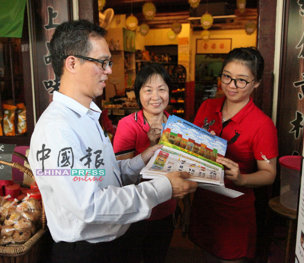 刘志良（左）去年底走访老街区，派送月历给当地商家与居民。