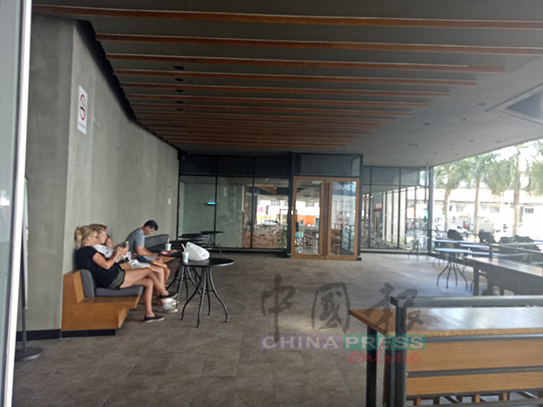 游客坐在“星巴克”外面的沙发，星巴克也必须在下午3时之后才可营业。