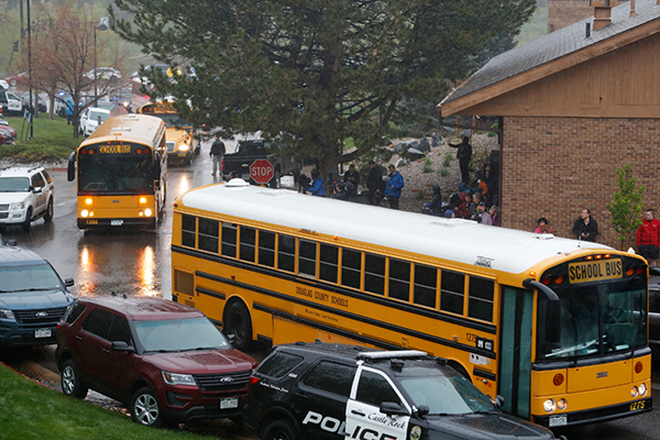 校车抵达学校，准备把疏散的学生接走。（美联社）