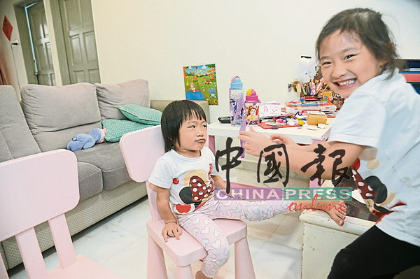羡颐（左）跟姐姐感情好，在家常常一起玩玩具。