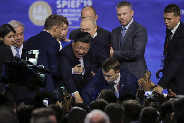 习近平在俄罗斯出席经济论坛期间差点跌倒，保镳（左）即时将他扶住。