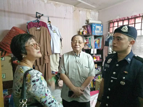 黄祥銮（左起）与林吉祥向警员了解房子漏水的情况。