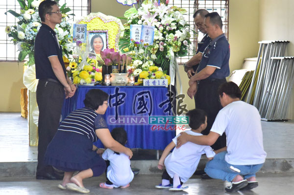 死者6岁大儿子及4岁大女儿，跪在灵堂上，需要旁人陪伴。
