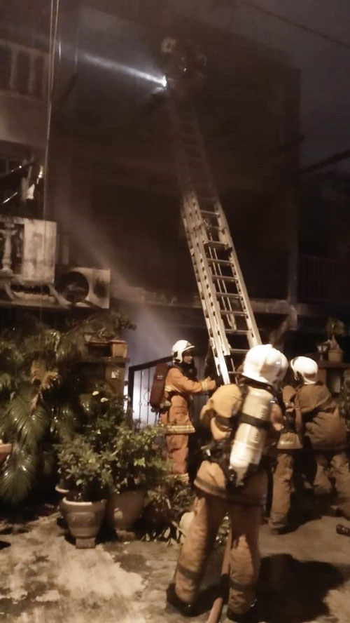 消拯员在扑灭火势后，利用云梯进入住家3楼检查。