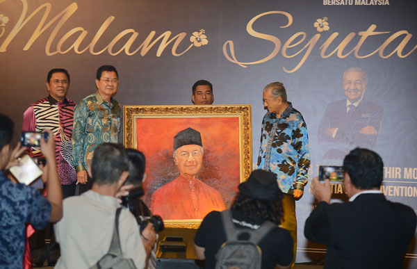 邝汉光（左）以10万令吉，标得马哈迪的画像。