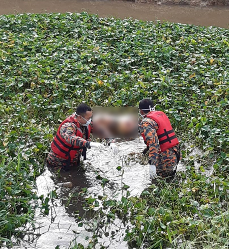 消拯员在河中的浮萍中将死者遗体捞起。