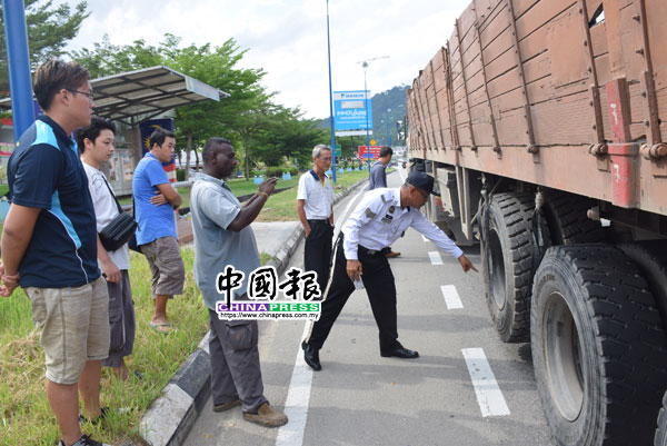 交通警员检查肇祸的拖格，左4为拖格司机。