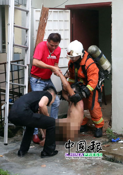 消拯员及公众合力抬出全身赤裸的华裔男租客。